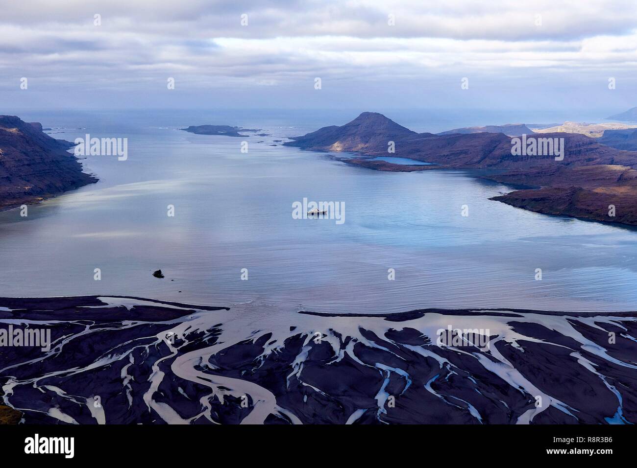 France, French Southern and Antarctic Territories (TAAF), Kerguelen Islands, Baie de la Table, the Marion Dufresne (supply ship of French Southern and Antarctic Territories) at anchor for supplying huts by helicopter, in the foreground the meanders of the plain Ampère (marine outwash plain of glacier Ampere (aerial view) Stock Photo