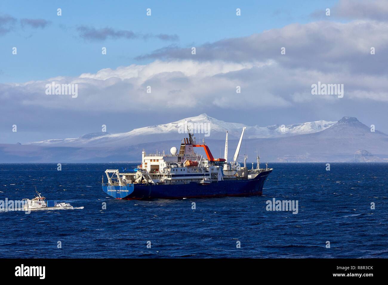 France, French Southern and Antarctic Territories (TAAF), Kerguelen Islands, Port-aux-Français, the Marion Dufresne (supply ship of French Southern and Antarctic Territories) at anchor in front of the station with the mounts of the peninsula of Ronac'h in the background Stock Photo