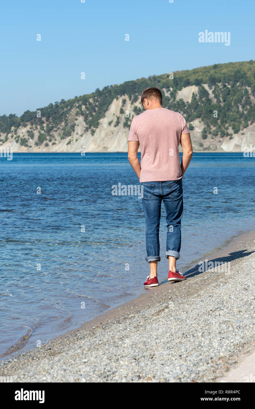 Man walking on the beach. Beautiful pebble beach Stock Photo - Alamy