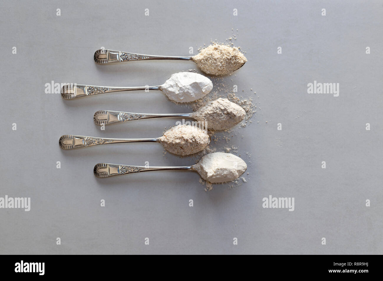 Five spoonfuls of different flours. From the top oat flour, rice flour