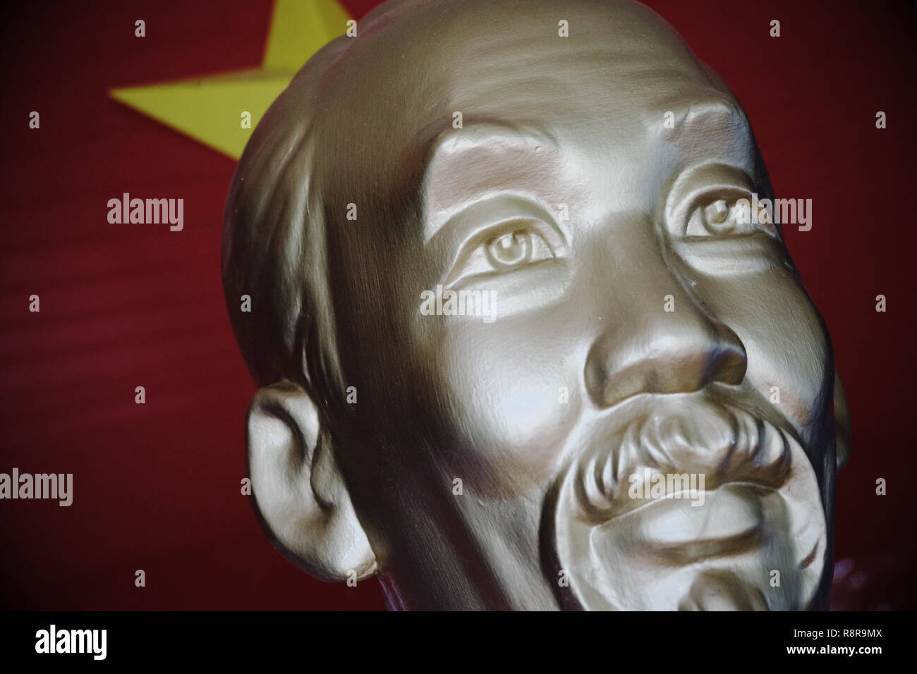 Vietnam statue of leader Ho Chi Minh with communist party flag behind Stock Photo