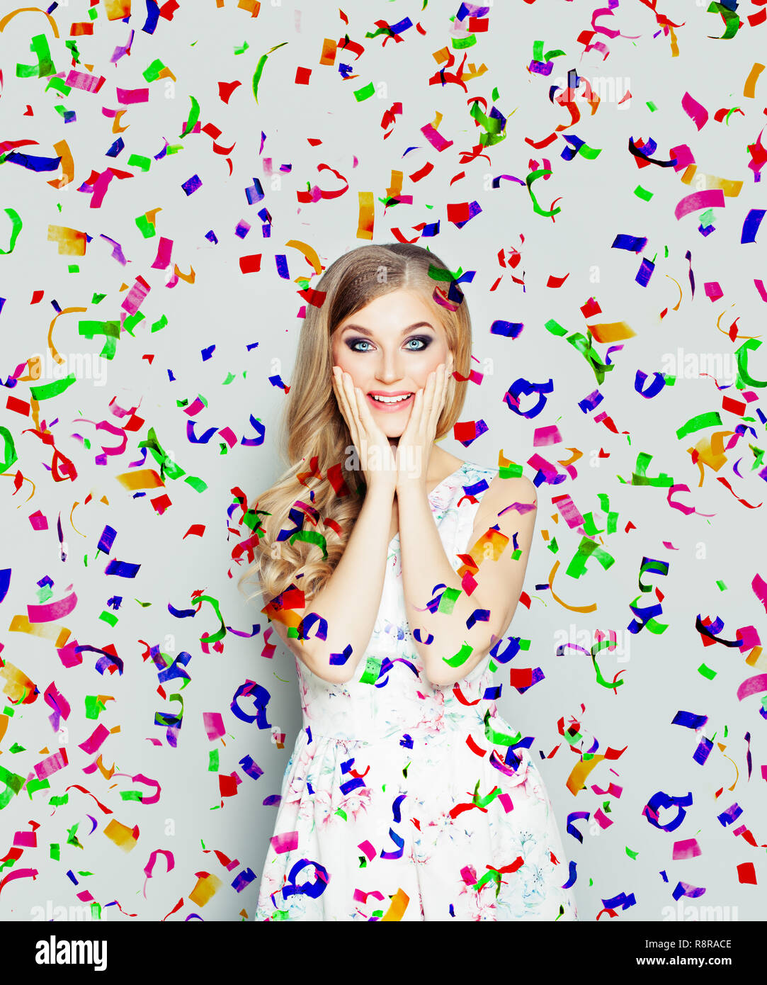 Happy surprised woman on holiday confetti background Stock Photo - Alamy
