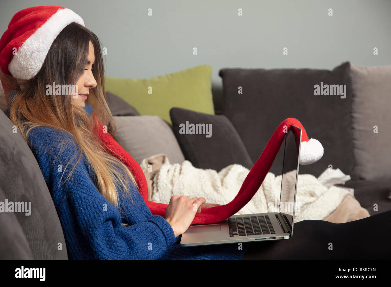 young woman sitting on the sofa, using a laptop Stock Photo - Alamy