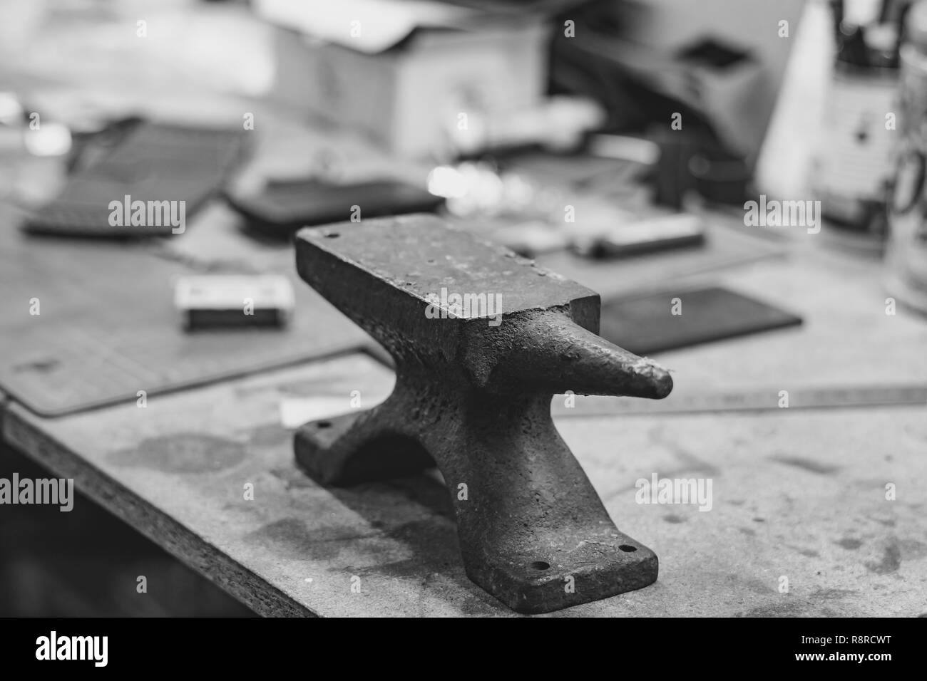 golden ring on an anvil and a goldsmith hammer in the jewelry