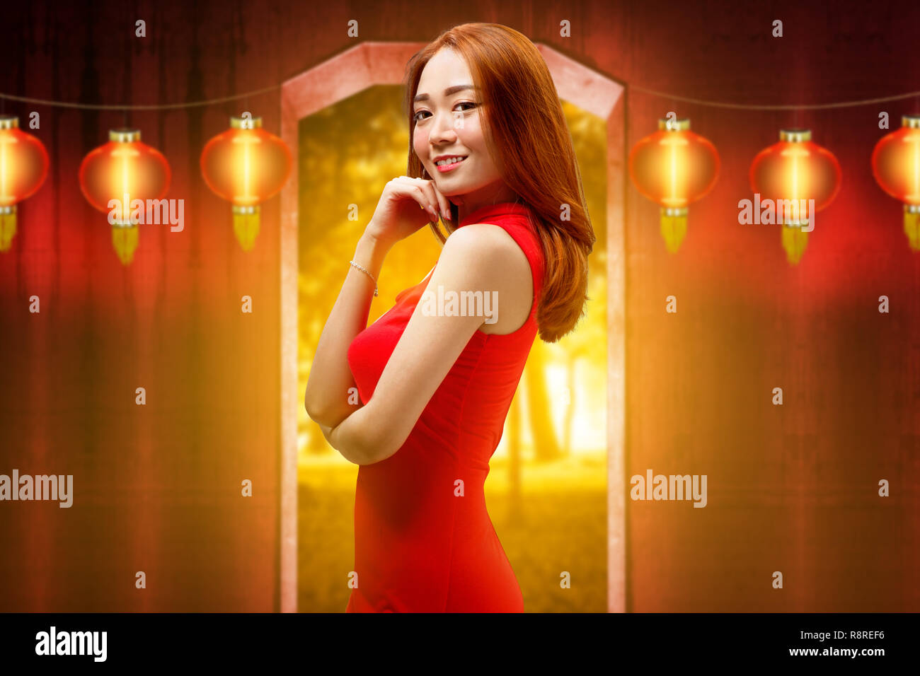 Happy chinese woman with traditional clothes posing against hanging lanterns on the background. Happy Chinese New Year Stock Photo