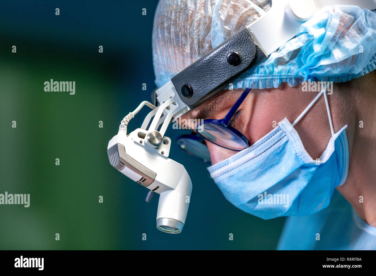 Female Doctor in Surgery Operating Hospital Room. Surgeon medic in protective work wear gloves, mask and cap Stock Photo
