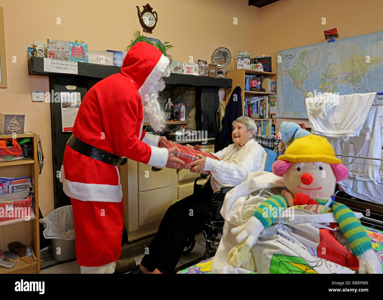 Elderly lady receiving gift from Father Christmas. Stock Photo