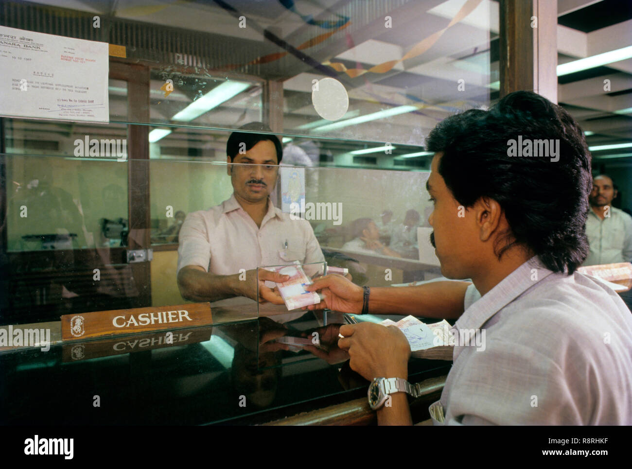 bank cashier giving cash to customer bank counter bangalore bengaluru karnataka india asia indian asian R8RHKF