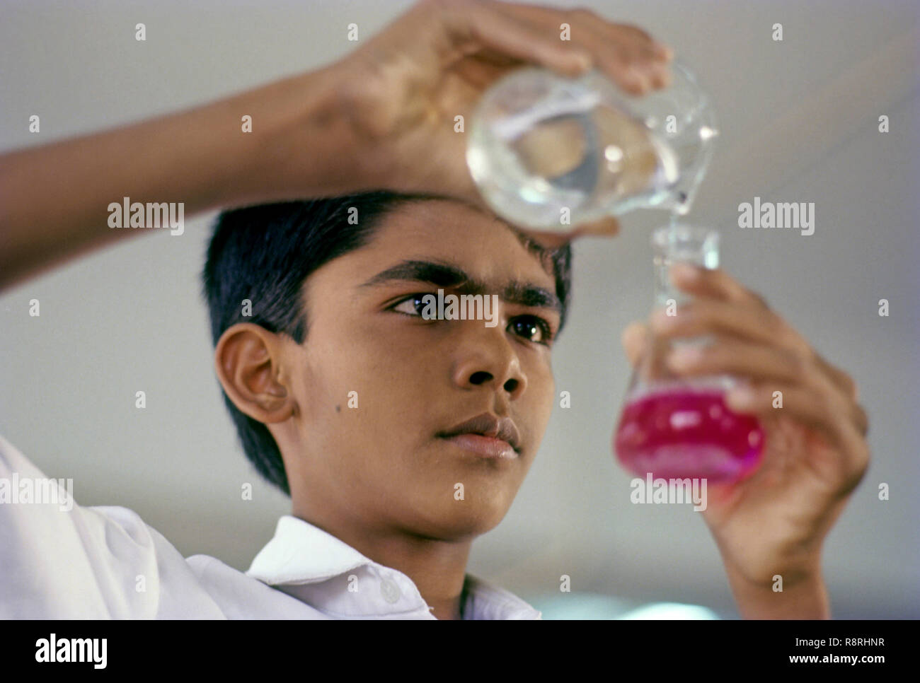 schoolboy doing chemistry practical in laboratory Stock Photo