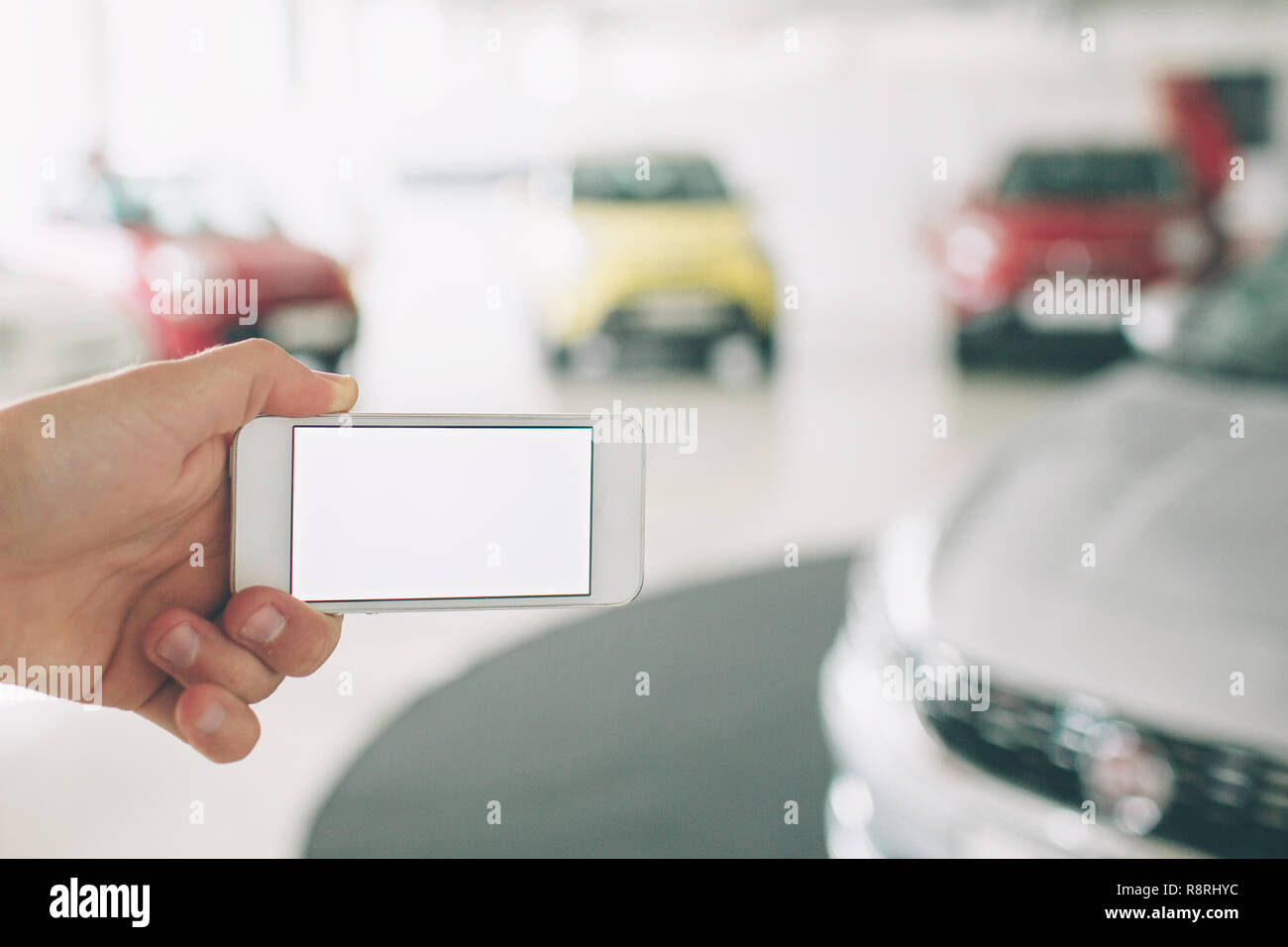 hand using phone white screen. Car sales, market place. cars showroom