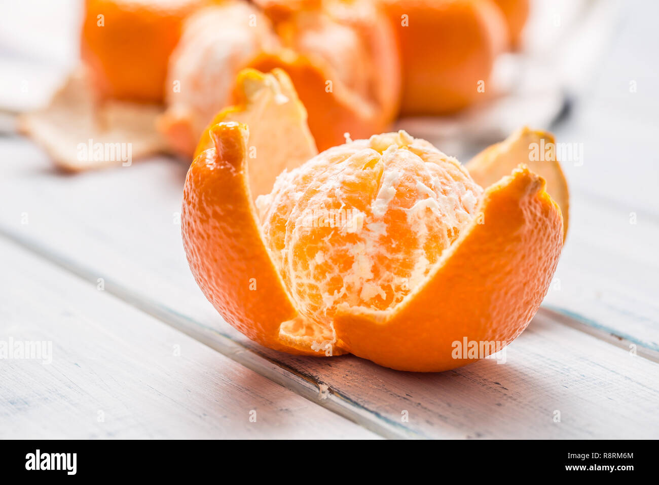 Fresh pieces of tangerines mandarin on wooden table. Stock Photo