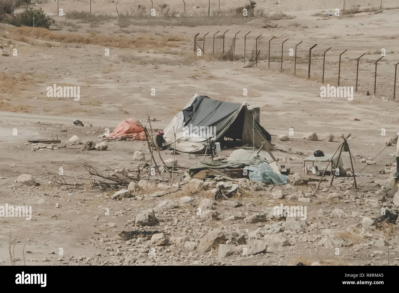 Bedouin houses in the desert near Dead Sea. Poor regions of the world. A indigent Bedouin sitting at the tent. Poverty in Jordan. middle East Stock Photo