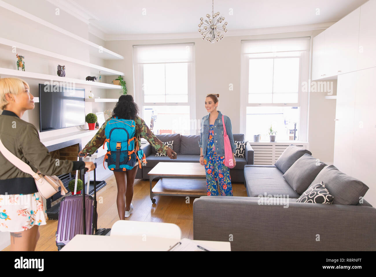 Young women friends with suitcases arriving at house rental Stock Photo