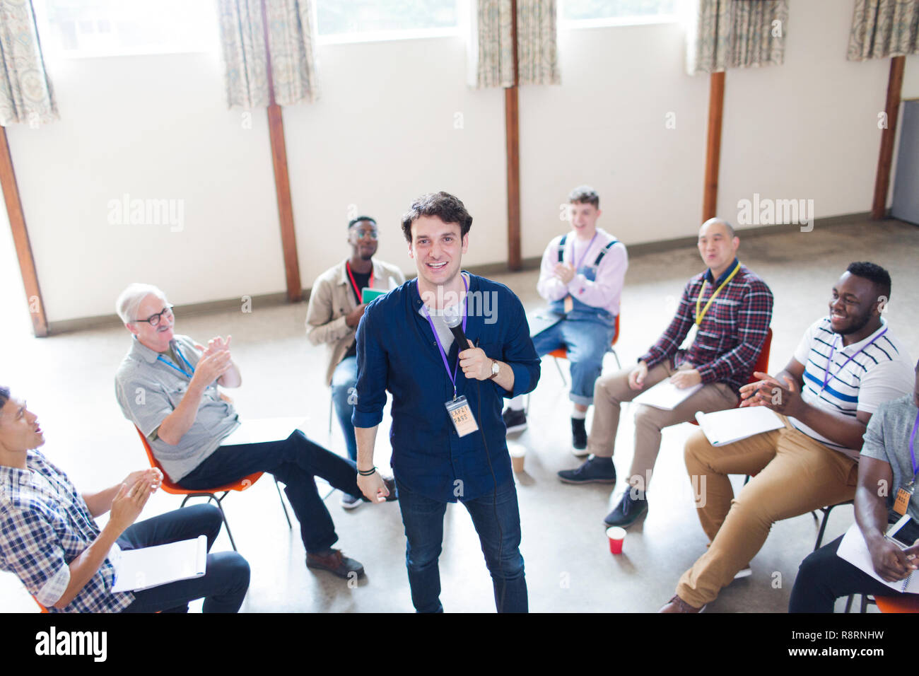 Men clapping for speaker in group therapy Stock Photo