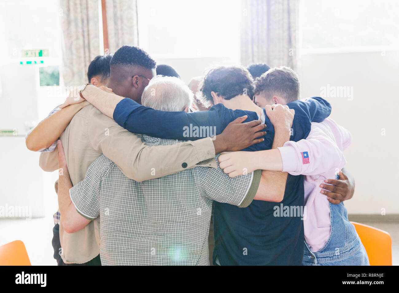 Men standing in huddle in prayer group Stock Photo