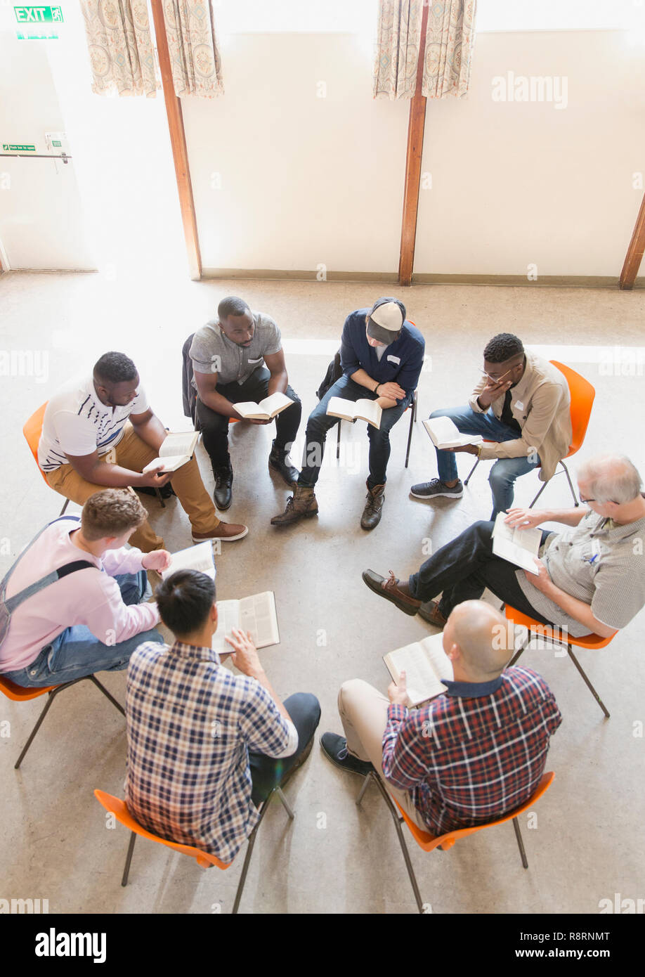 Men reading and discussing bible in prayer group Stock Photo