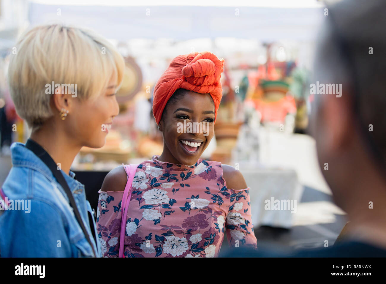 Happy young woman talking with friends Stock Photo