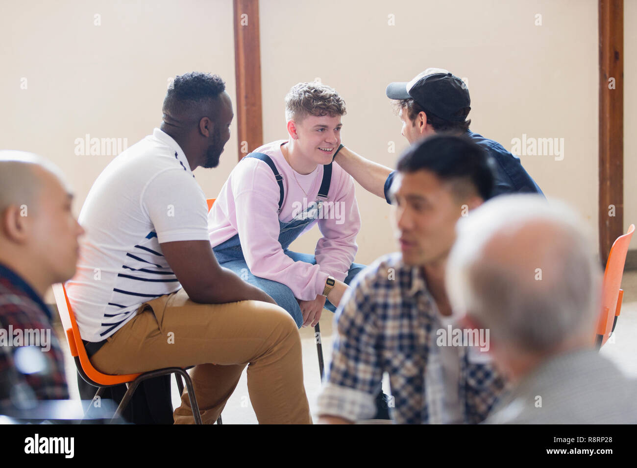 Men talking, comforting in group therapy Stock Photo