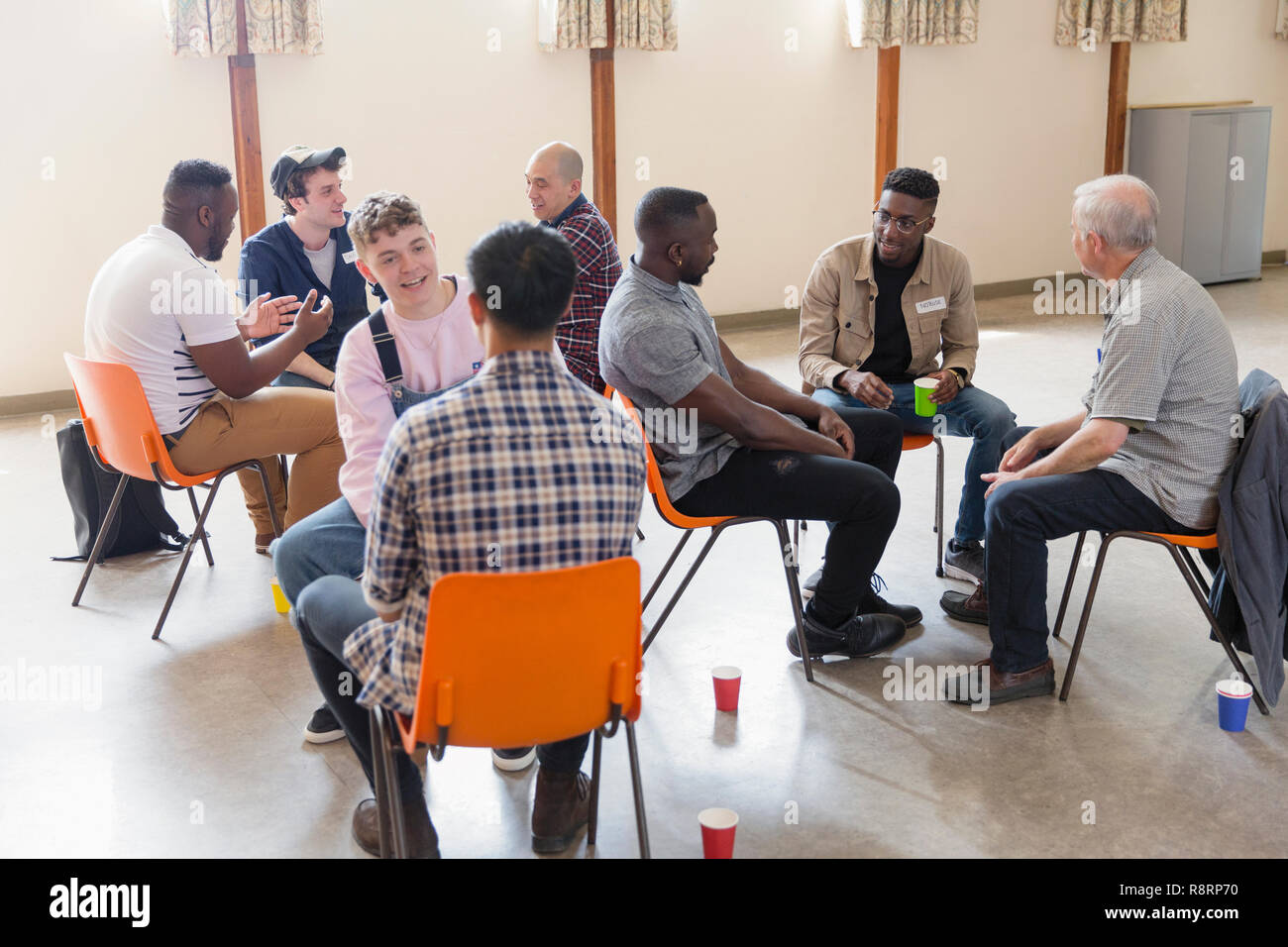 Men talking in group therapy in community center Stock Photo