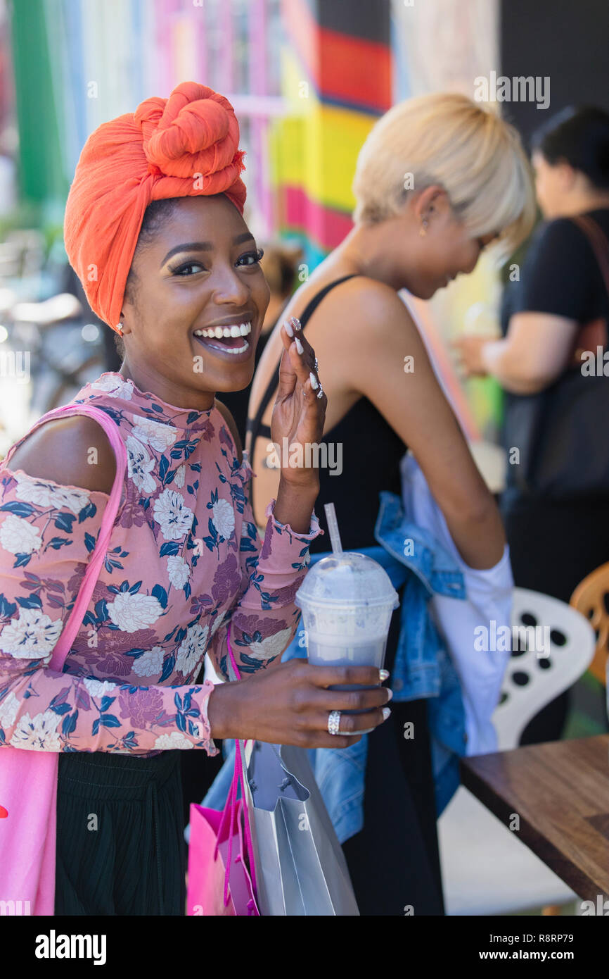 Portrait happy, carefree young woman in headscarf drinking smoothie Stock Photo