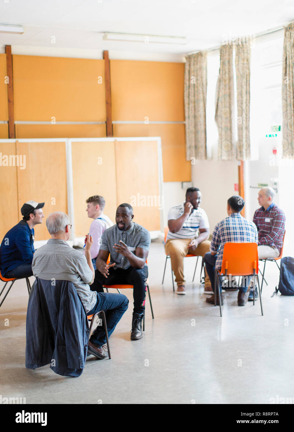 Men talking in group therapy in community center Stock Photo
