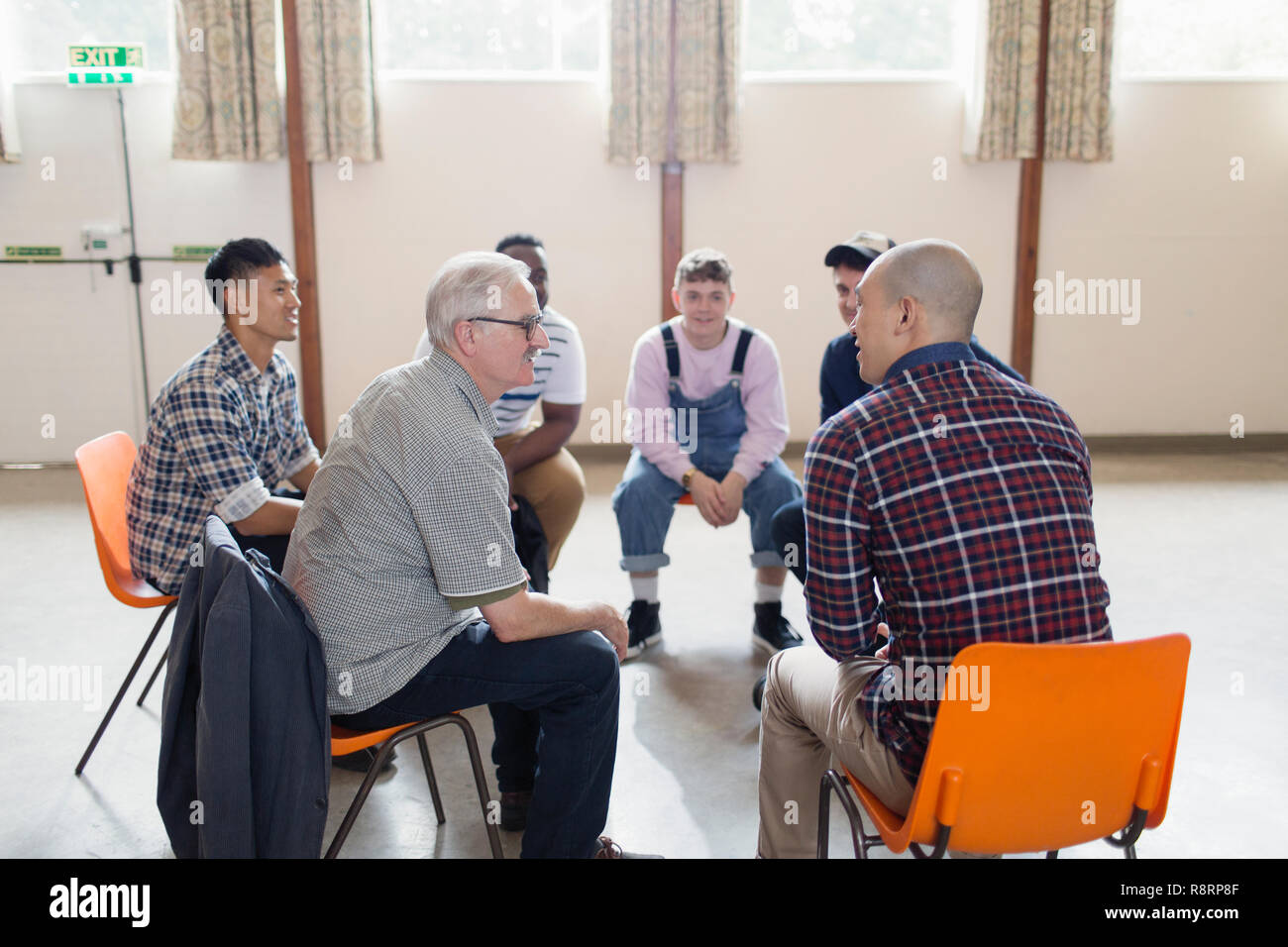 Men talking in group therapy circle Stock Photo