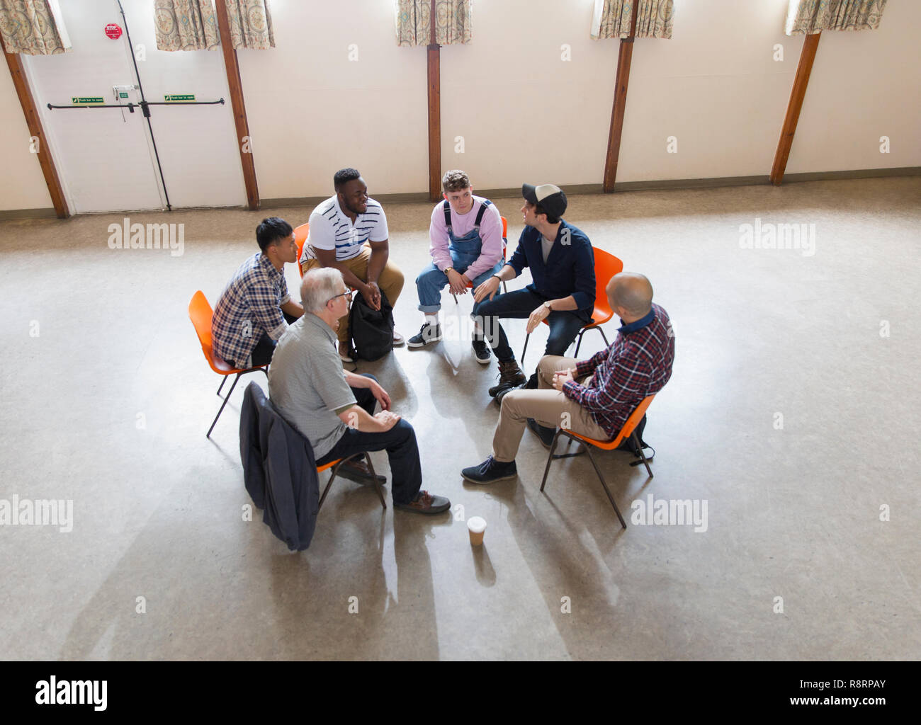 Men talking in group therapy circle Stock Photo