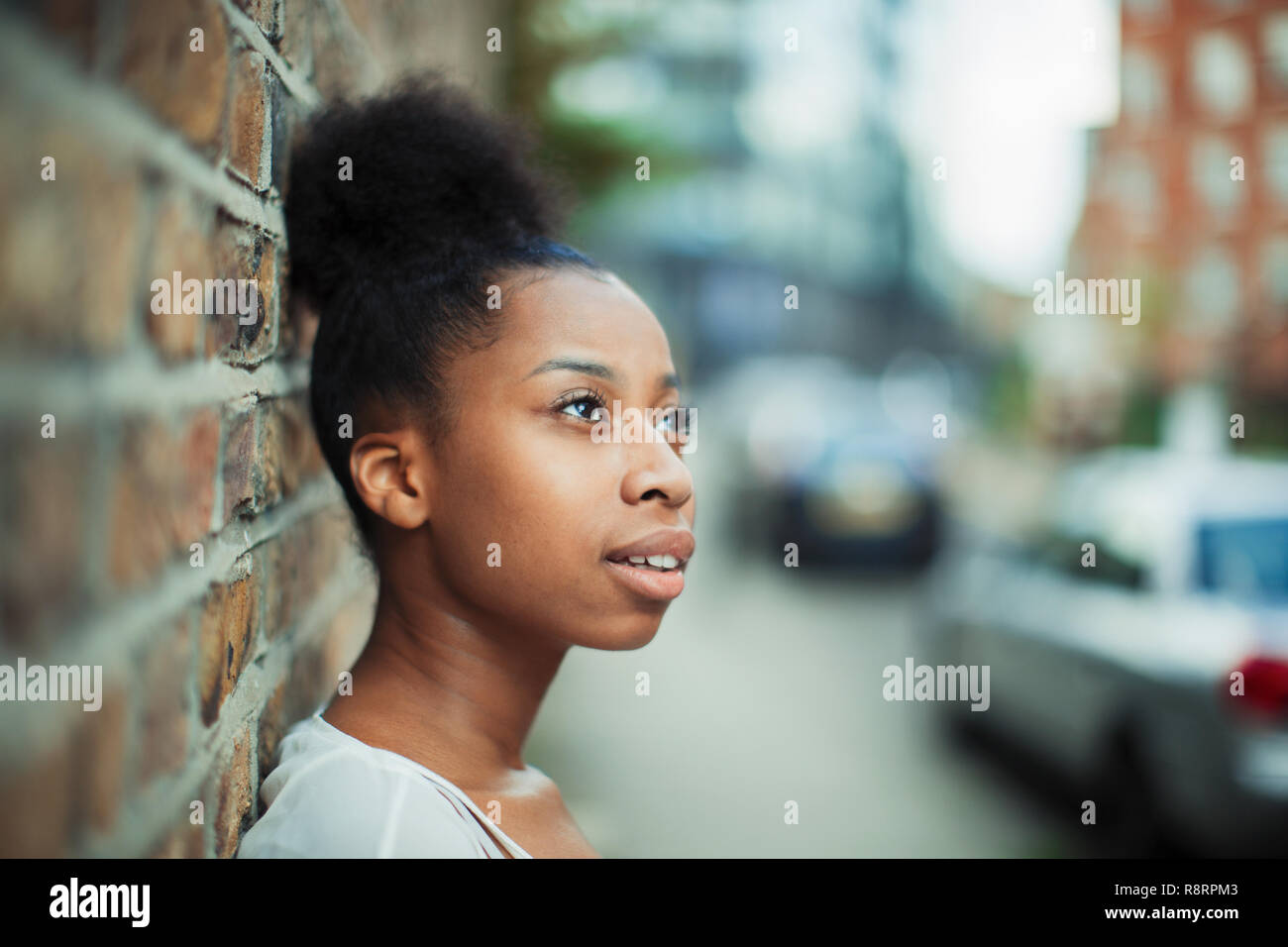 Thoughtful woman looking away on urban street Stock Photo