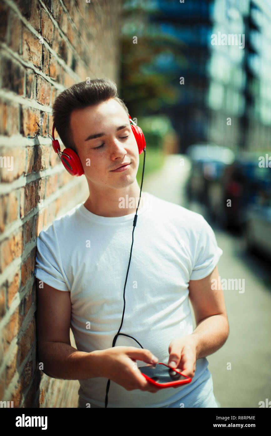 Serene young woman listening to music with headphones and mp3 player Stock Photo