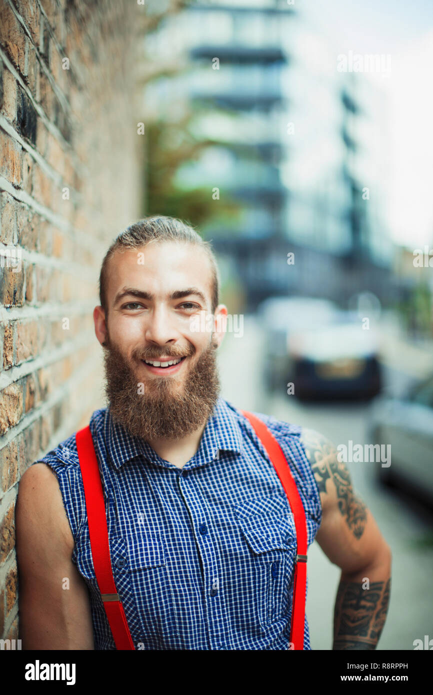 Portrait confident, smiling male hipster on urban sidewalk Stock Photo
