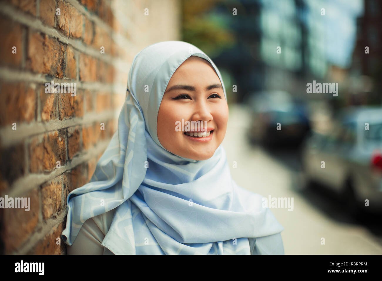Portrait smiling, confident young woman in blue silk hijab Stock Photo