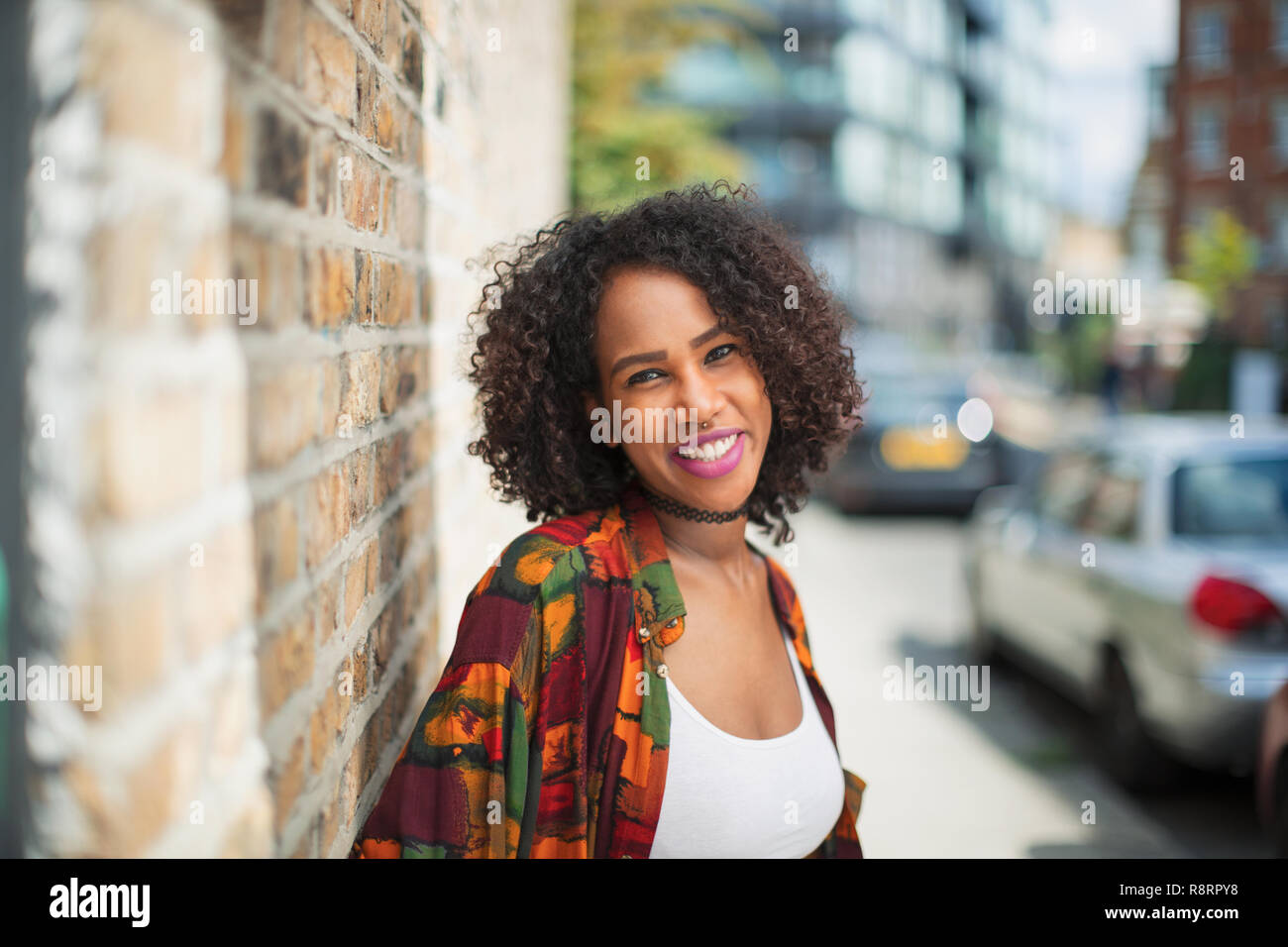 Portrait happy, confident young woman on urban sidewalk Stock Photo