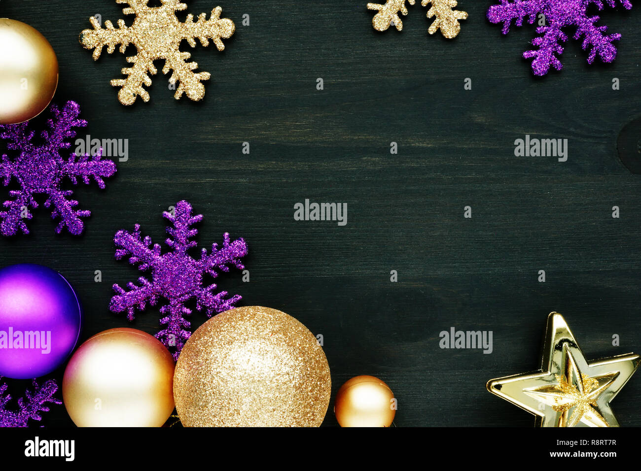 Christmas decoration balls and snowflakes on a dark wooden background with free space. Stock Photo