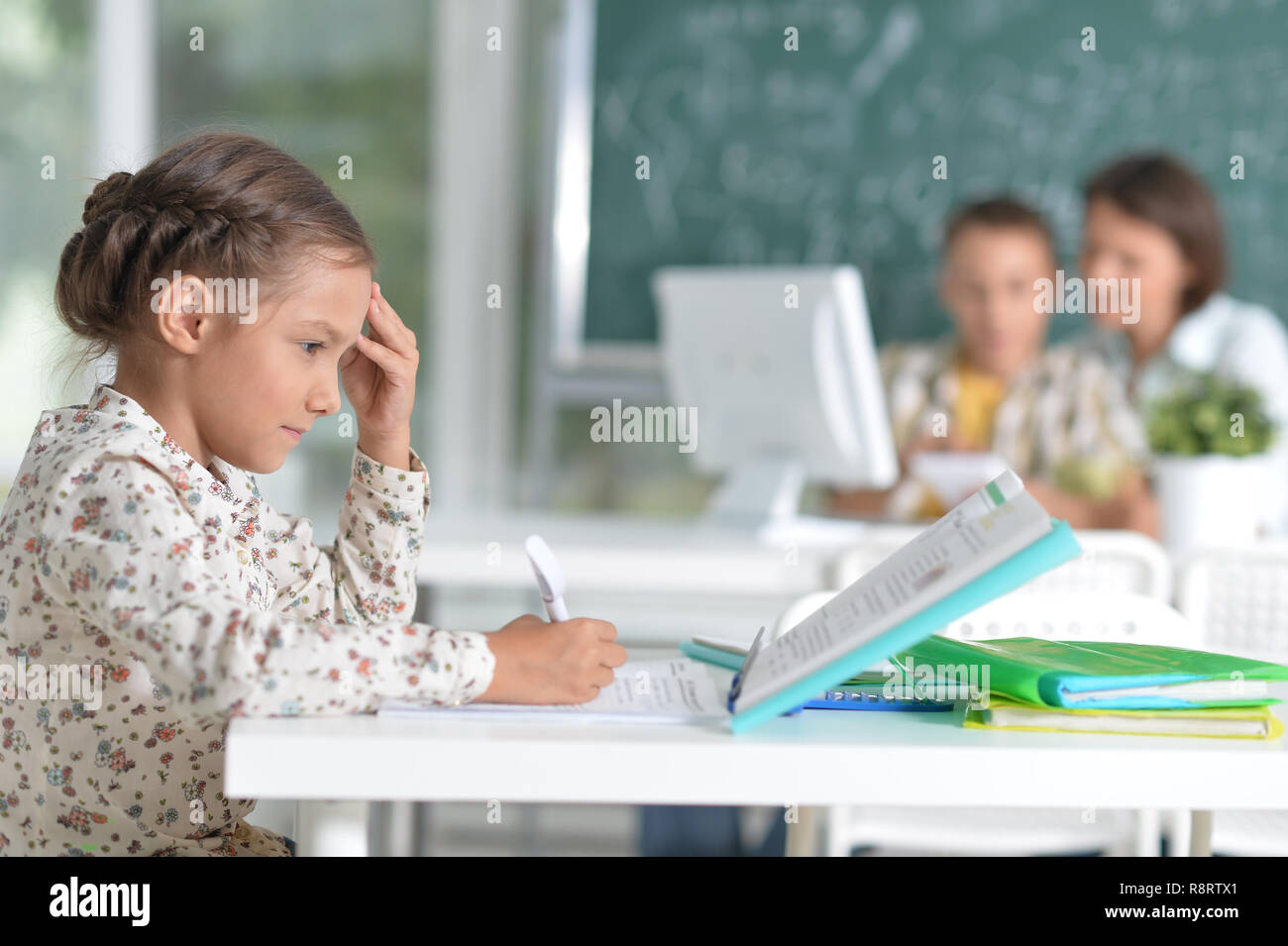 Portrait of cute little girl sitting in classroom Stock Photo - Alamy
