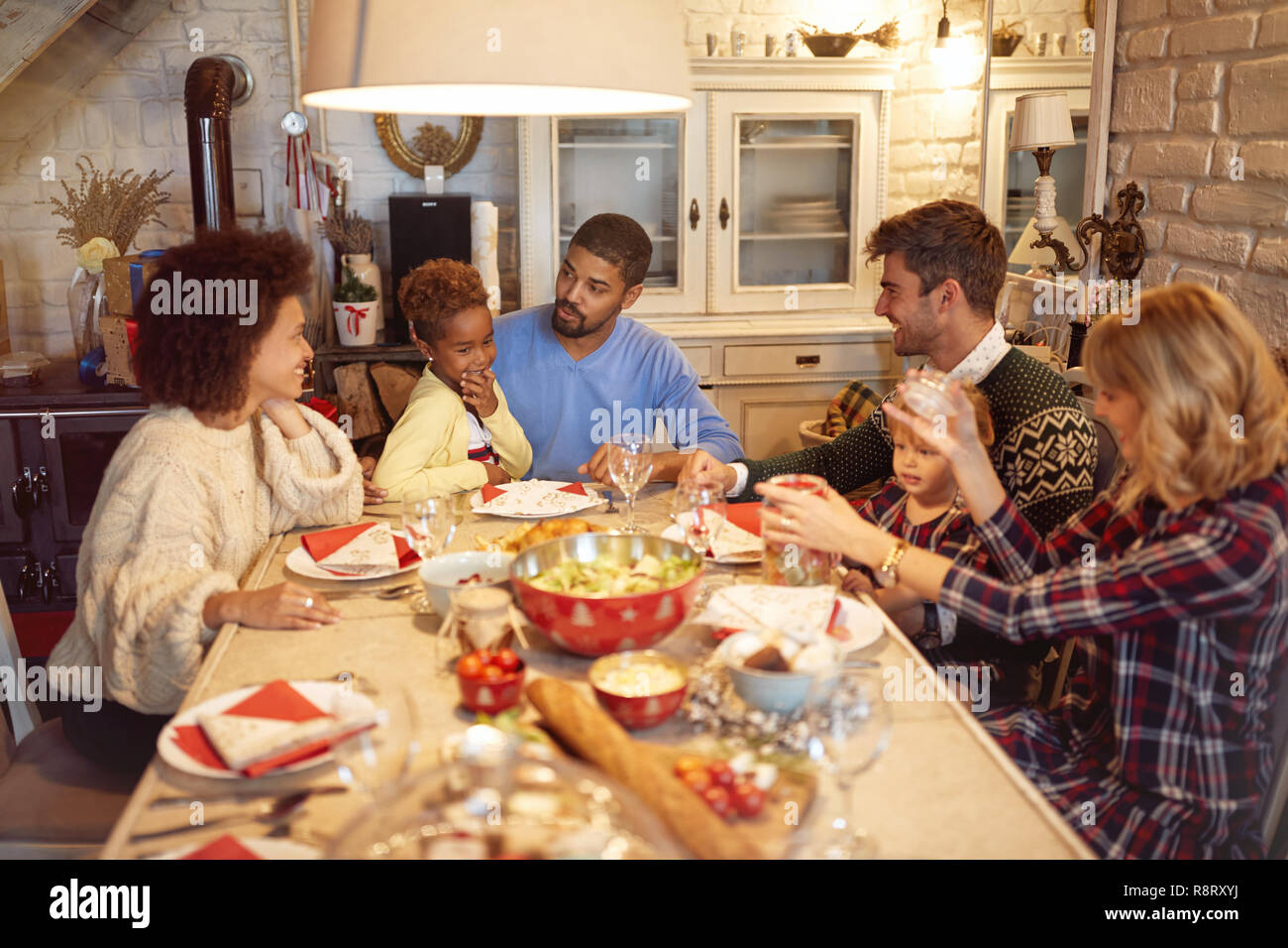 Smiling friends have fun at a family Christmas dinner Stock Photo