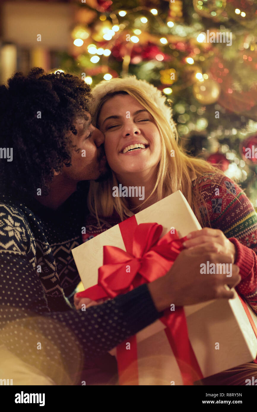 Romantic male and female exchanging Christmas presents and having fun ...