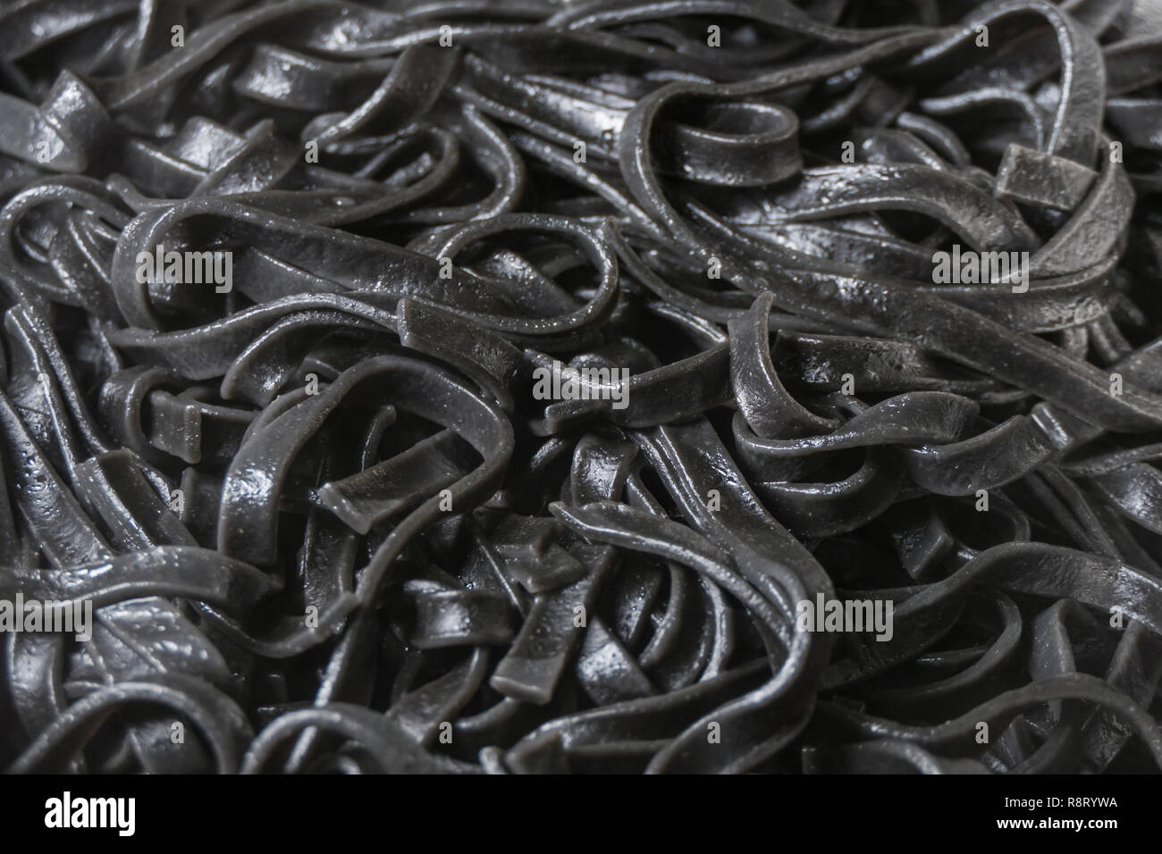 Black squid ink pasta fettuccine cooked background Stock Photo - Alamy