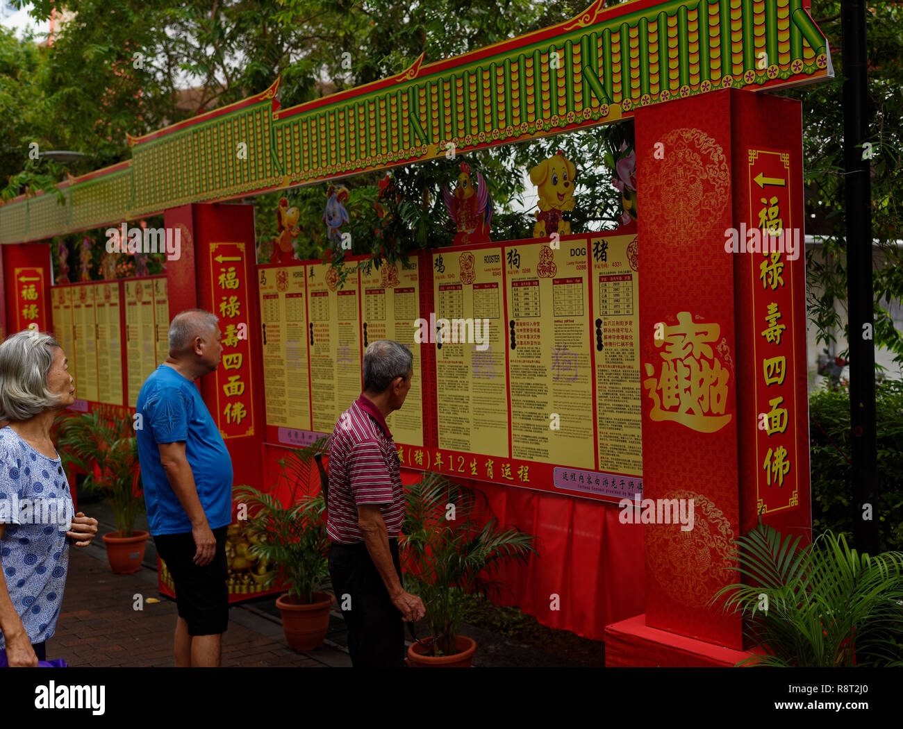 Local Chinese Singaporeans read their daily horoscope at Bugis Junction market, Singapore, Asia Stock Photo