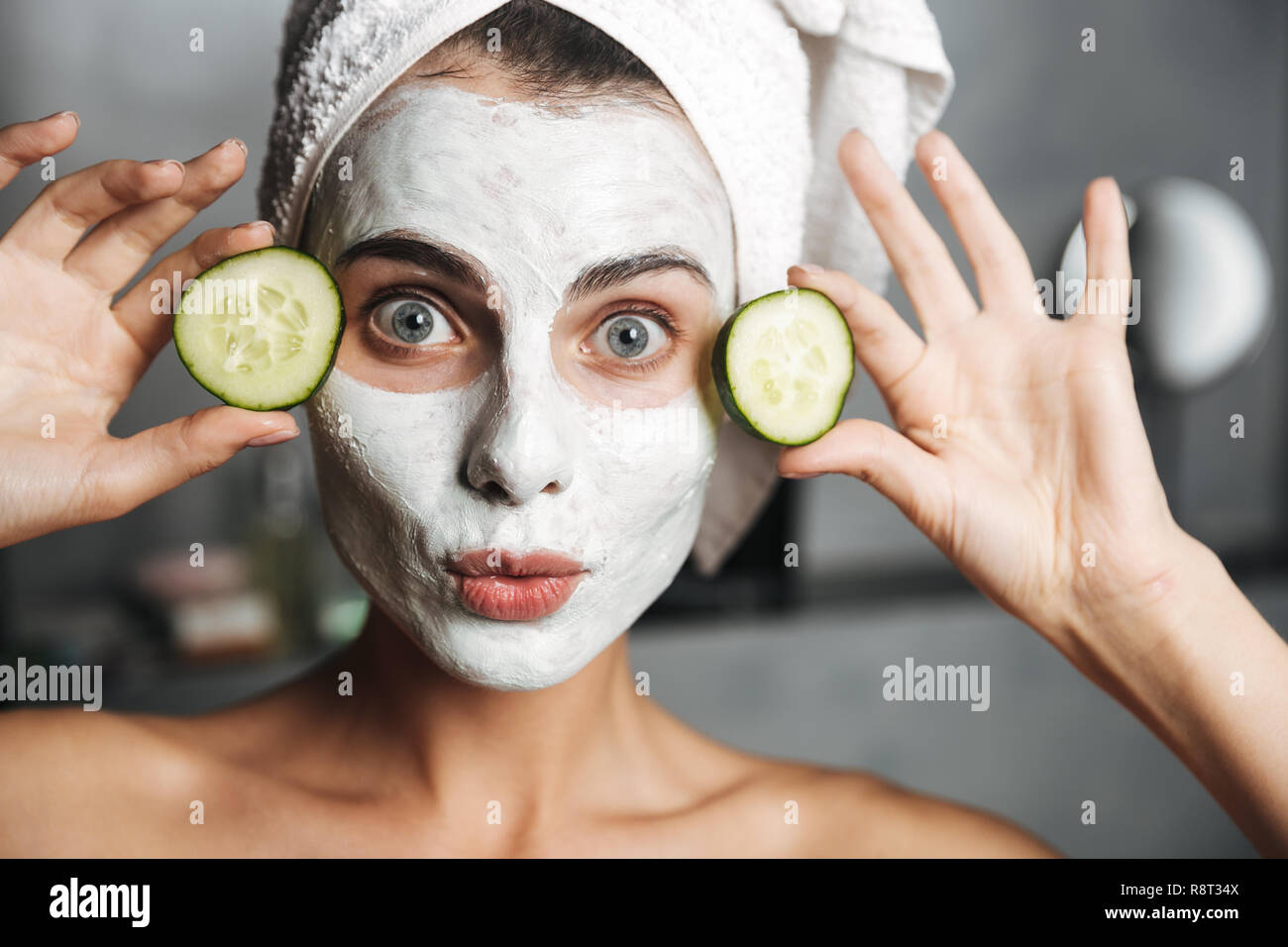 Beautiful young woman with towel wrapped around her head wearing face