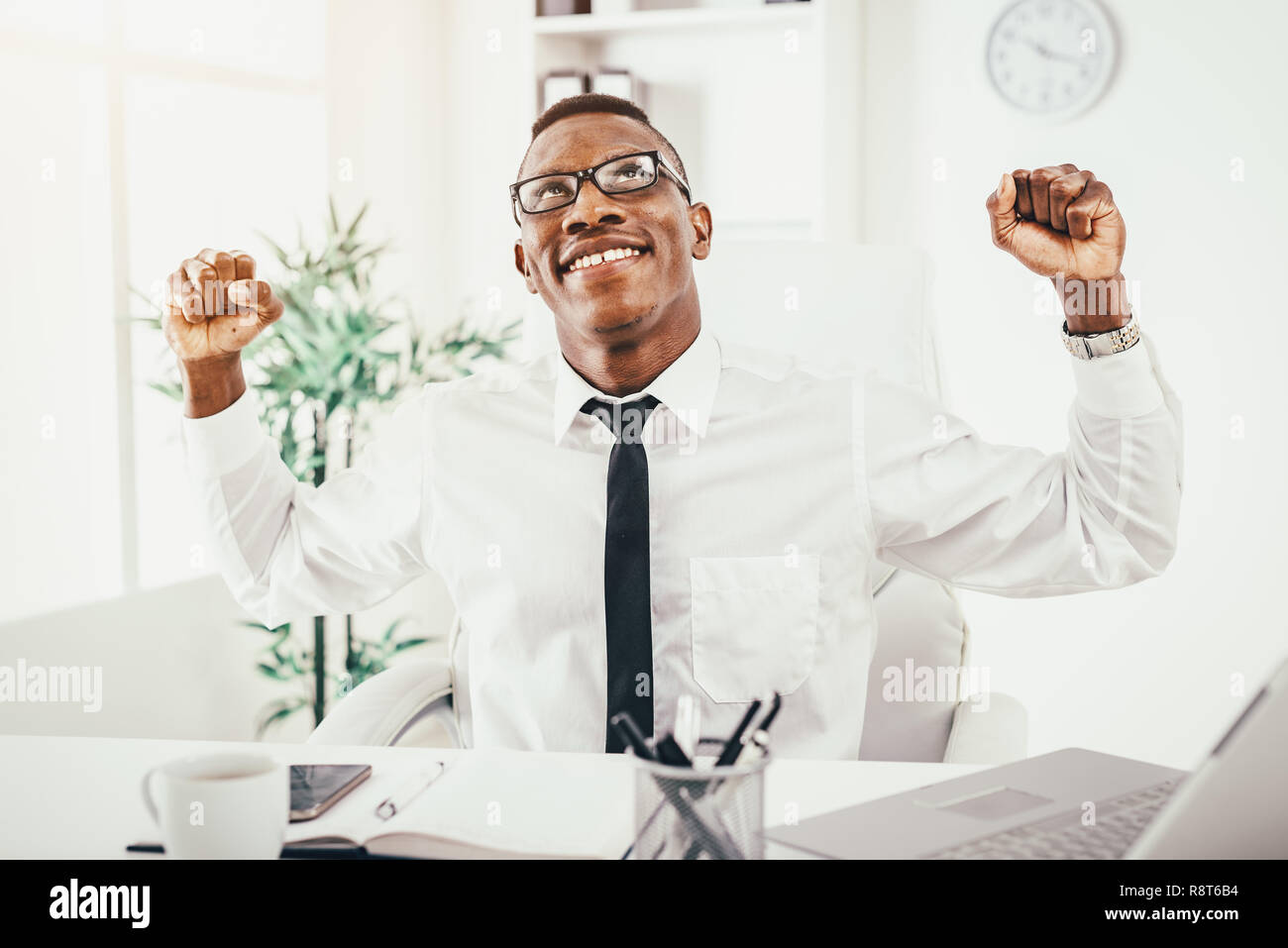 Successful African businessman celebrating success with fists in the ...