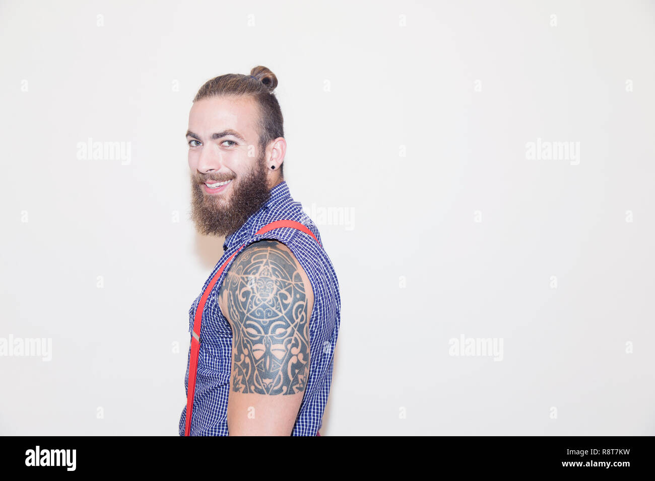 Portrait confident male hipster with shoulder tattoo Stock Photo