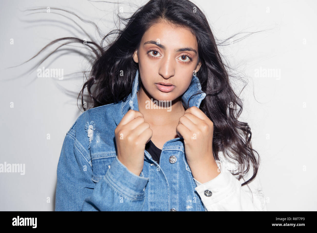Portrait confident, cool teenage girl in denim jacket Stock Photo
