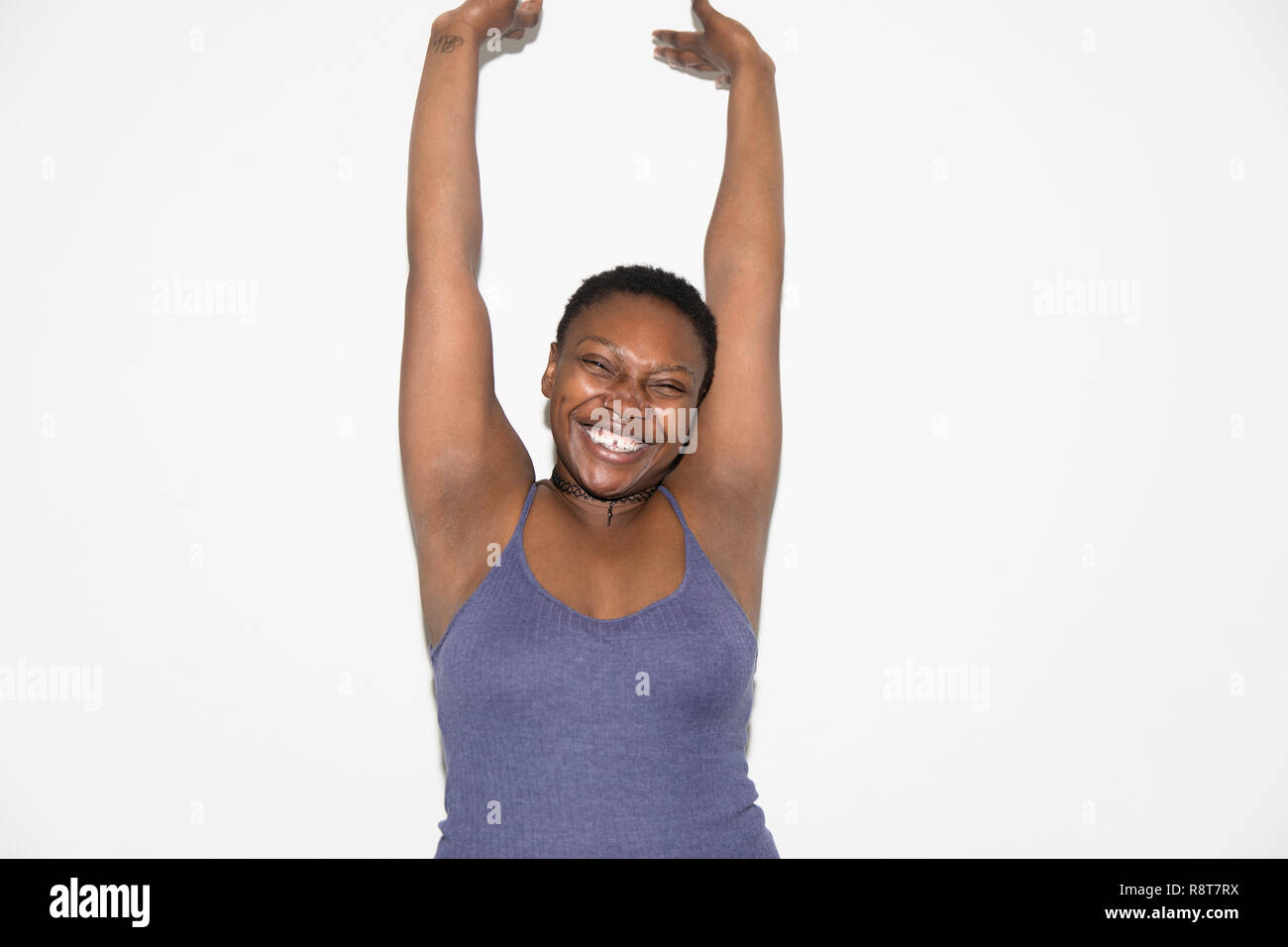 Portrait exuberant woman with arms raised Stock Photo