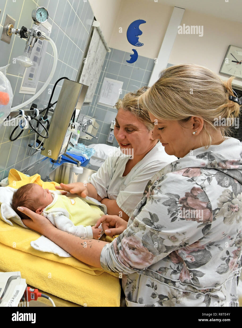 14 December 2018, Lower Saxony, Neustadt am Rübenberge: The five-day young twin girl Ella is cared for by her mother, Mrs. New Year (r), and by midwife Zinovia Aramidou (l) at the Neustadt am Rübenberge Clinic in the Clinic for Gynaecology and Obstetrics. Many maternity clinics in Lower Saxony are under massive pressure because midwives and nursing staff are missing. There are currently six vacancies for midwives in the three maternity clinics of the Klinikum Region Hannover (KRH) in Neustadt am Rübenberge, Gehrden and Großburgwedel. (on dpa 'Lack of midwives threatens the existence of materni Stock Photo