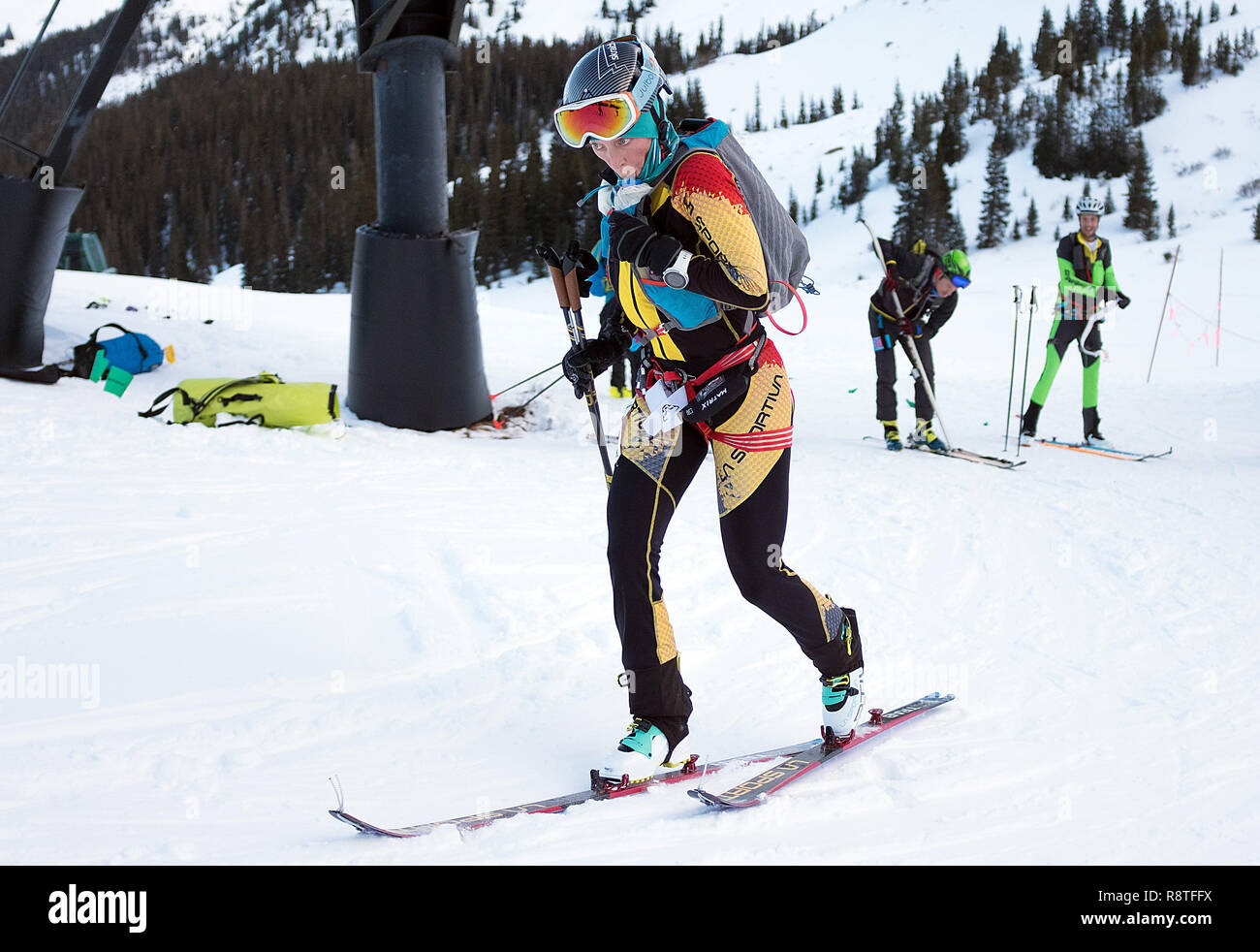 December 15, 2018: A La Sportiva ski mountaineering racer takes a quick  drink while leaving the transition area after applying climbing skins to  skis during the difficult United States Ski Mountaineering Association's