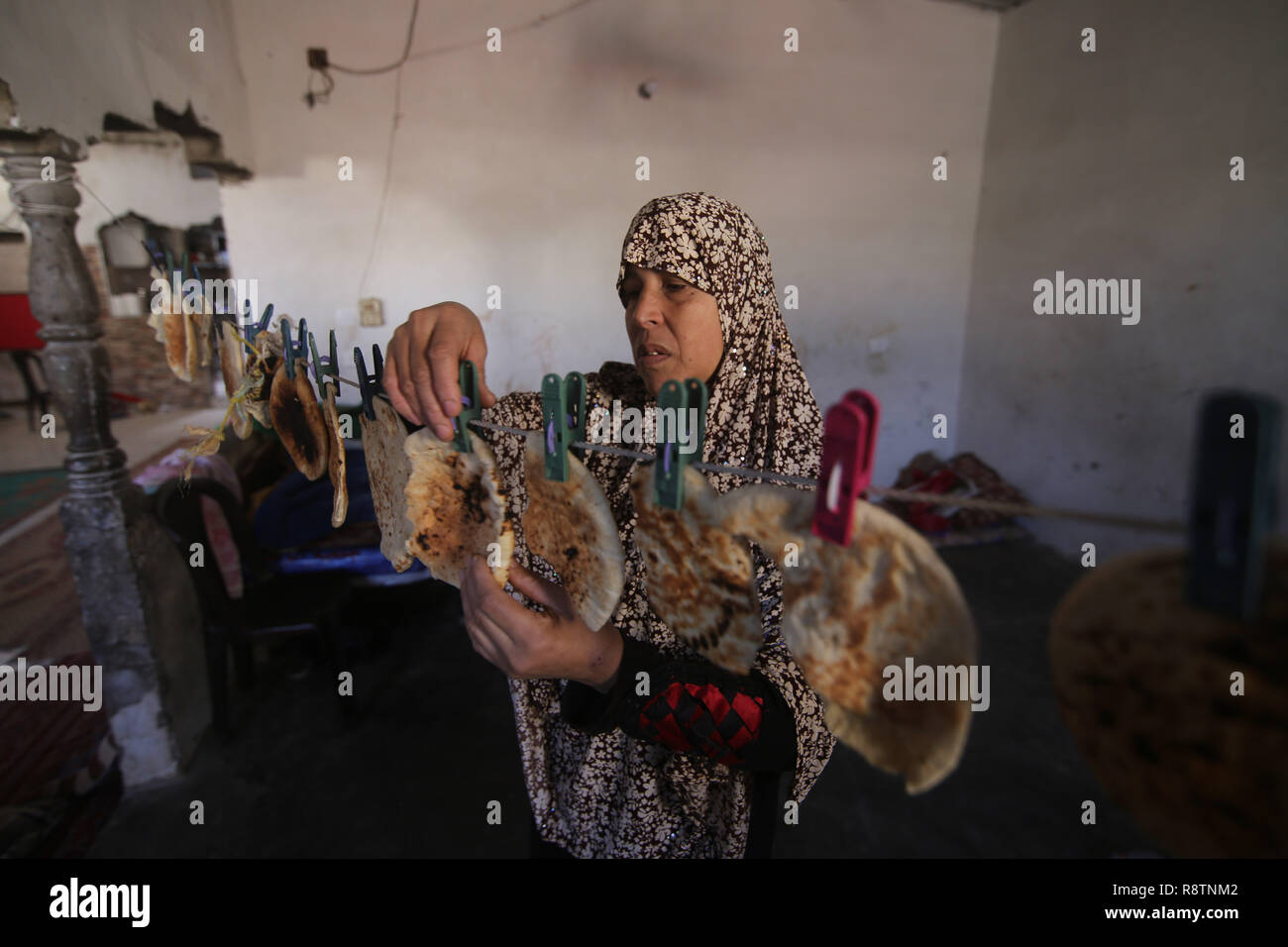 Gaza. 18th Dec, 2018. Palestinian woman Fayrouz al-A'raj, 45, dries bread remains inside her house, in the southern Gaza Strip city of Khan Younis, on Dec. 18, 2018. Fayrouz al-A'raj sells bread remains to livestock owners to feed their animals. Credit: Khaled Omar/Xinhua/Alamy Live News Stock Photo