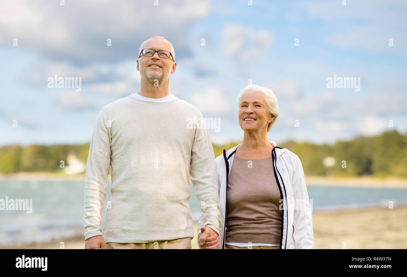happy senior couple over beach background Stock Photo - Alamy