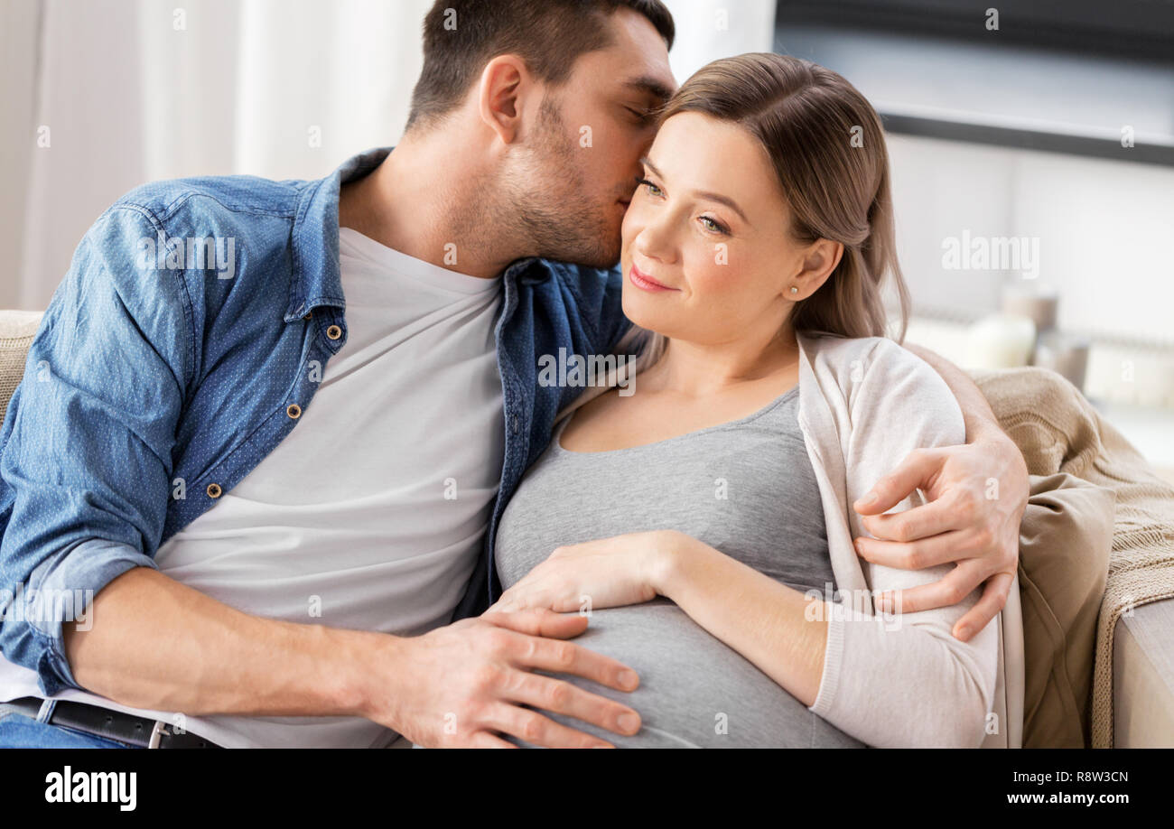 Беременную женщину обнимают. Беременная женщина дома на диване парочка. Обнять беременную женщину. Беременная женщина с мужем. Фотосессия с животиком.