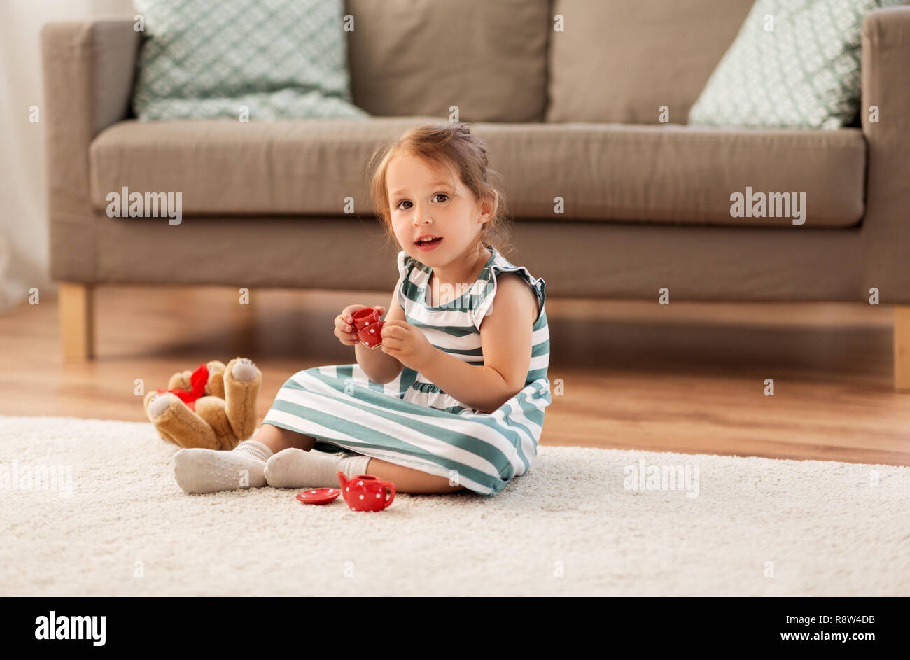 little girl playing with toy tea set at home Stock Photo - Alamy
