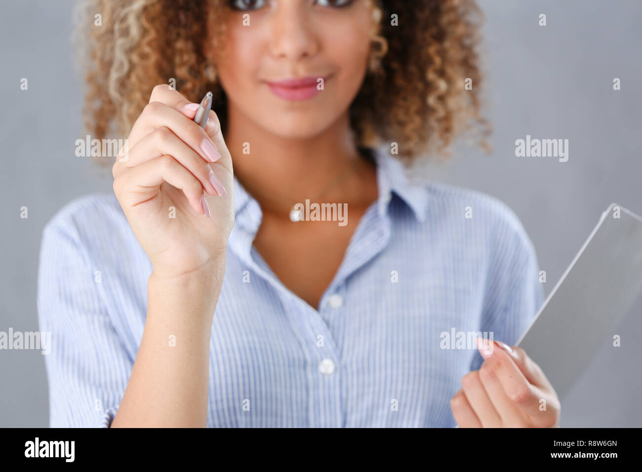 Beautiful black woman portrait. Holds a ballpoint pen Stock Photo - Alamy
